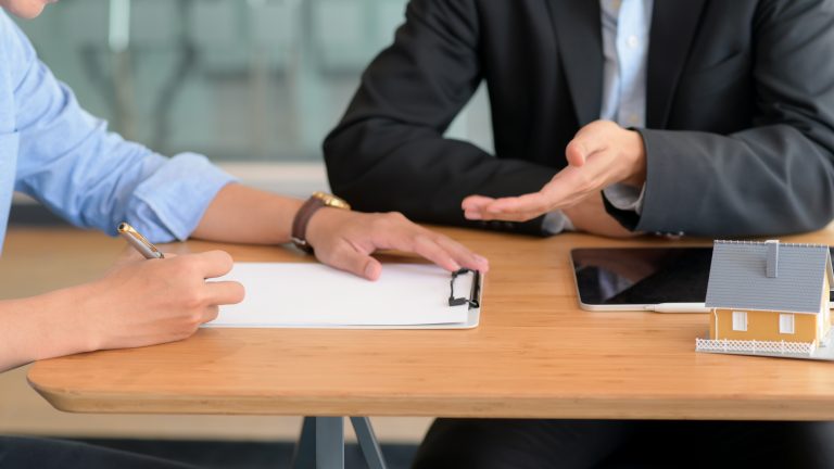 Customer signs a home loan agreement with a bank representative.